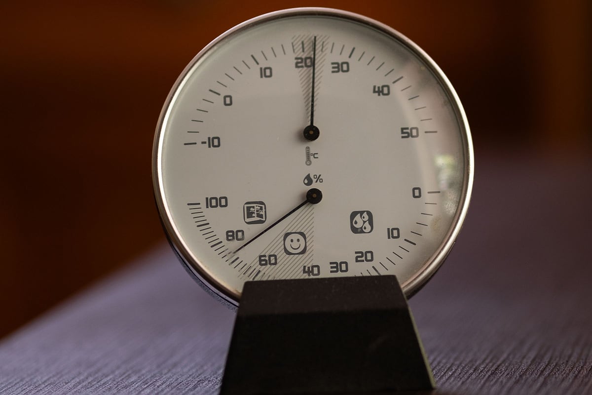 Analoges Hygrometer und Thermometer nebeneinander an einer Wand